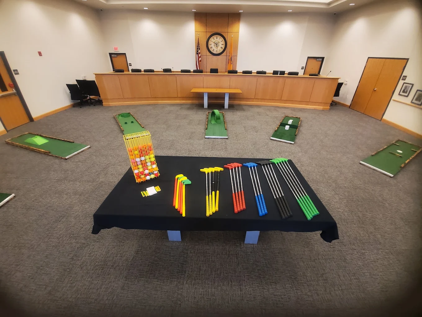 Colorful mini golf putters and balls laid out for a corporate event