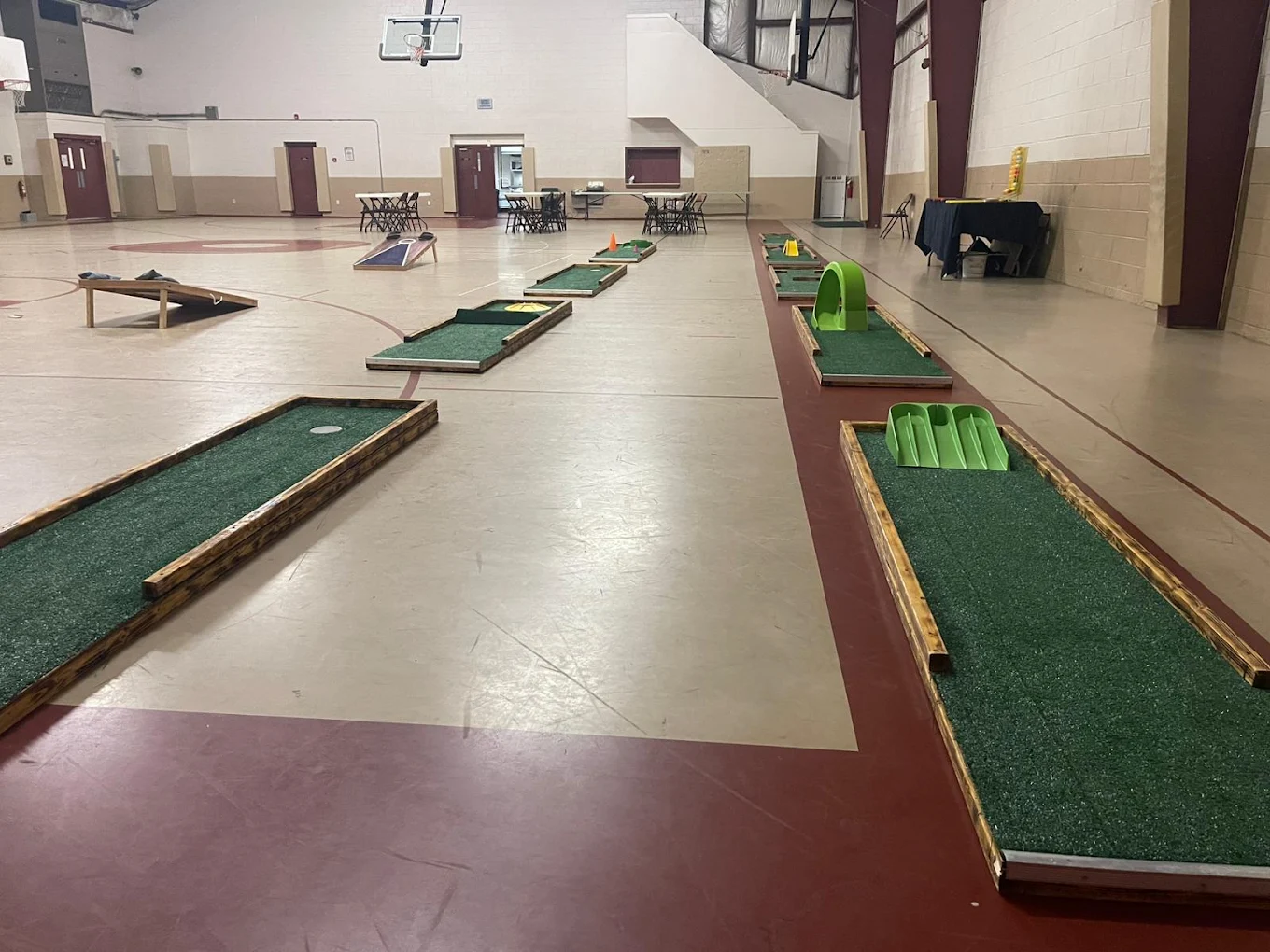 Yard games and mini golf lanes ready to play in a school gymnasium