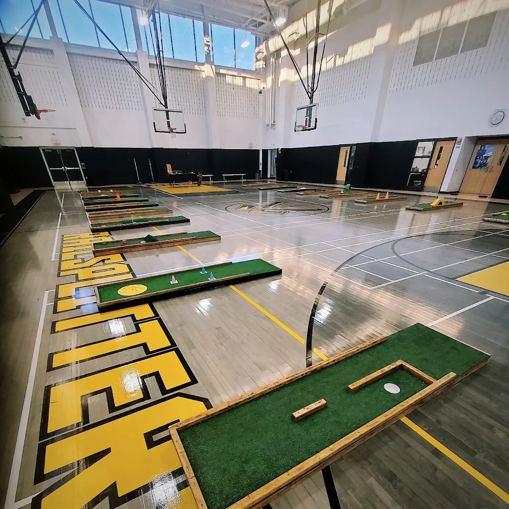 Wide school gymnasium set up for a mini golf and laser tag event