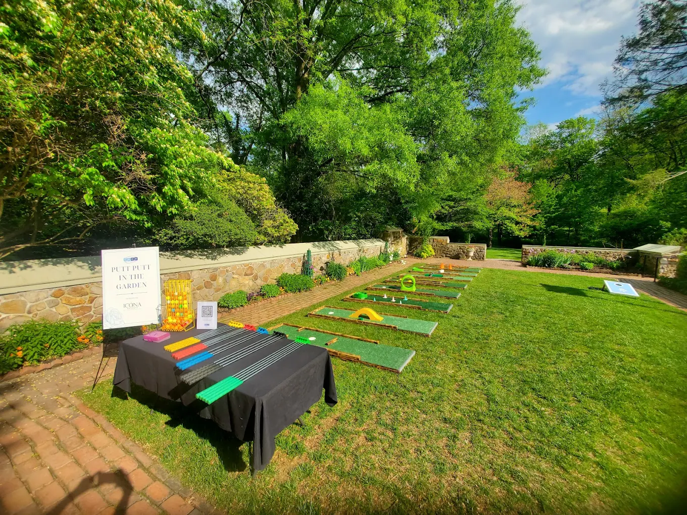 Portable mini golf course set up in a lush garden for a private event